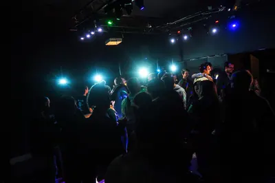 Salle de club sous les projecteurs, public de dos