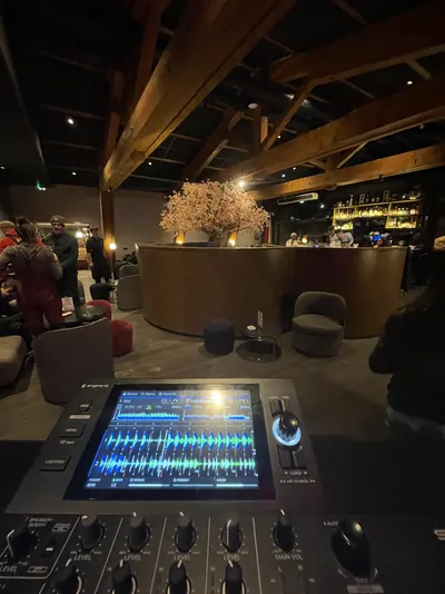 Écran de la table de mixage, bar de chalet et arbre en fleurs en fond